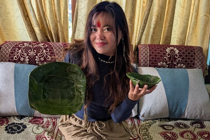 A group of participants holding up the leaf plates they made during the traditional workshop
