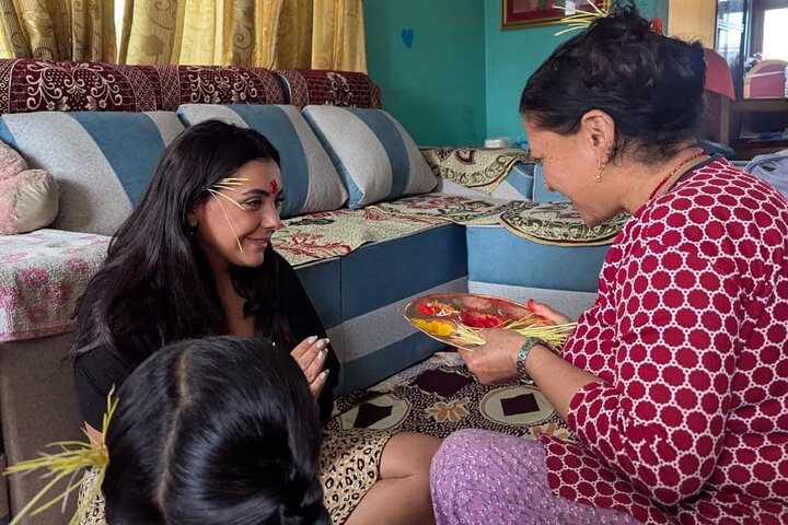 A participant closely watching an artisan’s hands demonstrating how to make a leaf plate