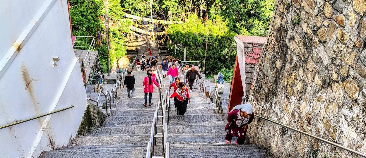 Visitors walking up the stairs to Swayambhunath Monkey Temple in Kathmandu on guided walking tour
